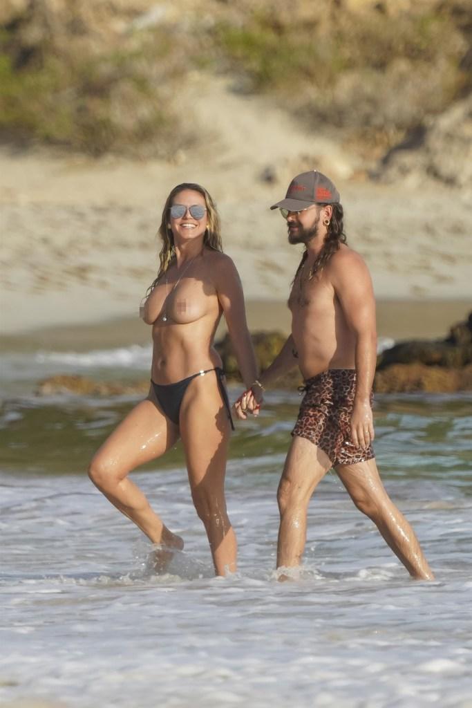 Klum wore only a pair of black bikini bottoms, a long silver necklace and aviator shades to hit the beach on Monday. 
