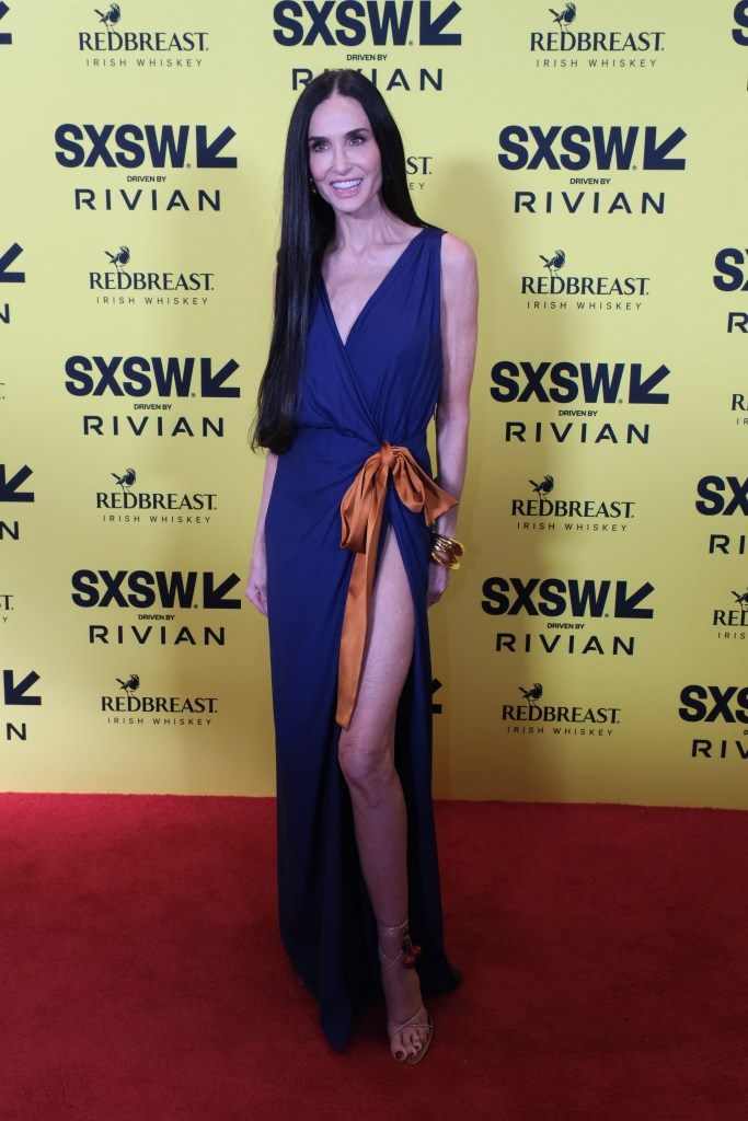 Синее платье-халат было перевязано оранжевым бантом на талии.