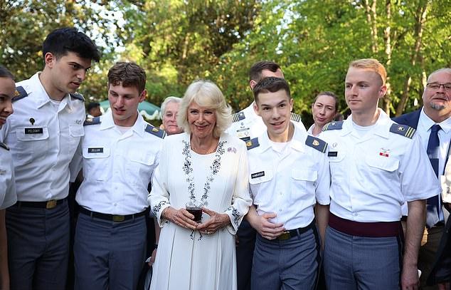 Камилла (в центре) позирует с военными курсантами во время вечеринки в саду