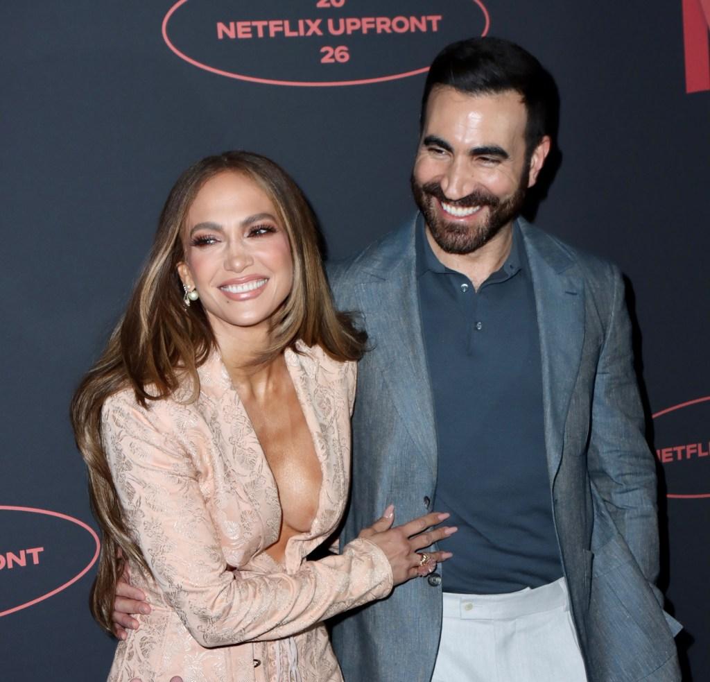 В среду на красной дорожке презентации Netflix 2026 года Дженнифер Лопес и Бретт Голдштейн, звезды фильма «Офисный роман», нежно обнимались
