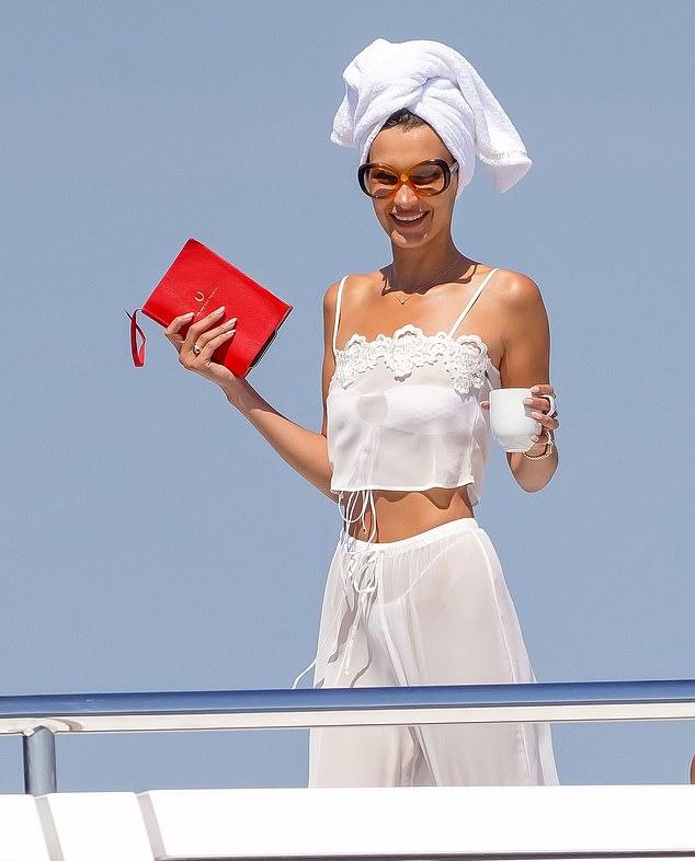 Представительница бренда Prada начала утро в прозрачной майке и брюках, демонстрируя нижнее белье, и пила чай, держа в руках красный дневник с изображением подковы